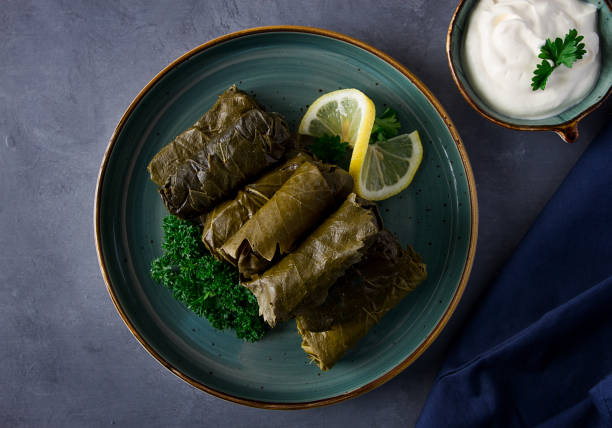 istock Dolma, cabbage rolls, grape leaves with filling, white sauce, lemon and herbs, rustic, selective focus, no people, 1377921091