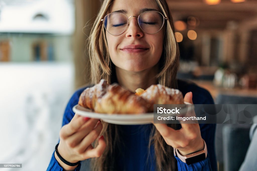 Teenage girl having breakfast Teenage girl having breakfast in restaurant. She is smelling fresh, warm croissants.
Canon R5 Food Stock Photo
