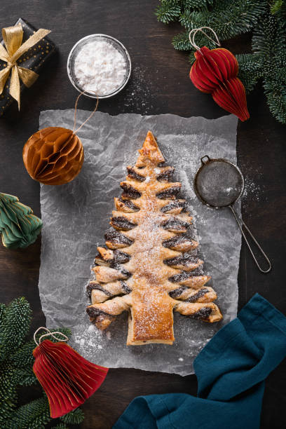 istock Puff pastry Christmas tree with chocolate paste, sprinkled with powdered sugar on old dark wooden background. Christmas or Xmas pastries. Top view. Copy Space 1377929430