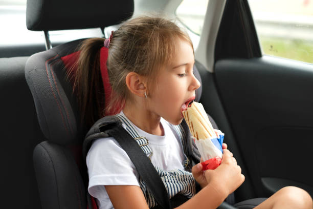 istock A child eats a hot dog in a car. 1377955257