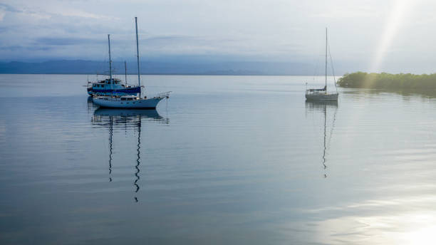 istock Anchored sailing boat making natural reflection over the water. 1377960645