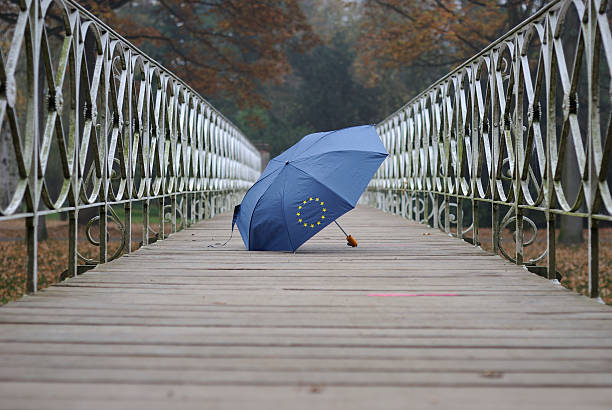 European currency crisis Blue umbrella with golden stars on a historical bridge. european union symbol stock pictures, royalty-free photos & images