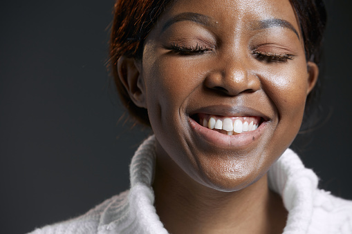 Laughing beautiful african american young woman with toothy smile, closed eyes, having fun. Positive sincere emotions. High quality photo