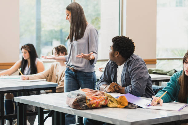 istock Female teacher walks through classroom giving instructions for test 1378027108