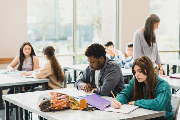 istock Two teen students work independently in busy classroom 1378027624