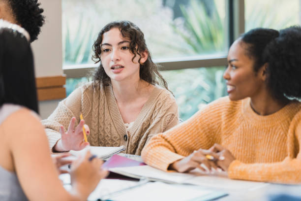 istock Working together on project, students listen to female classmate 1378027630