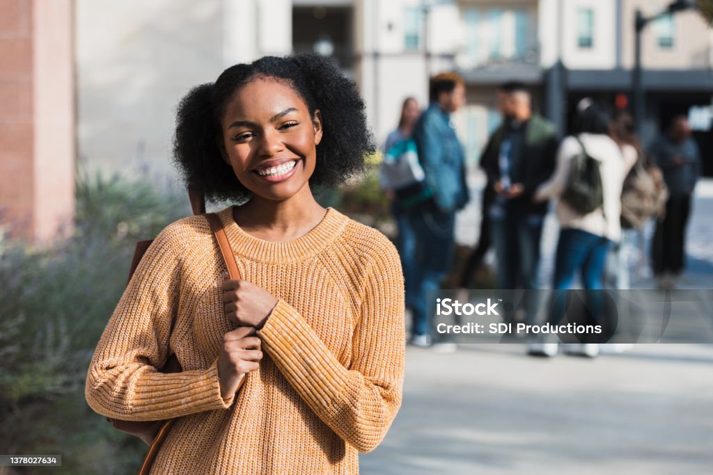 Before joining friends on field trip, teen smiles for camera Before joining her classmates on the field trip, the female high school student smiles for a photo. Student Stock Photo