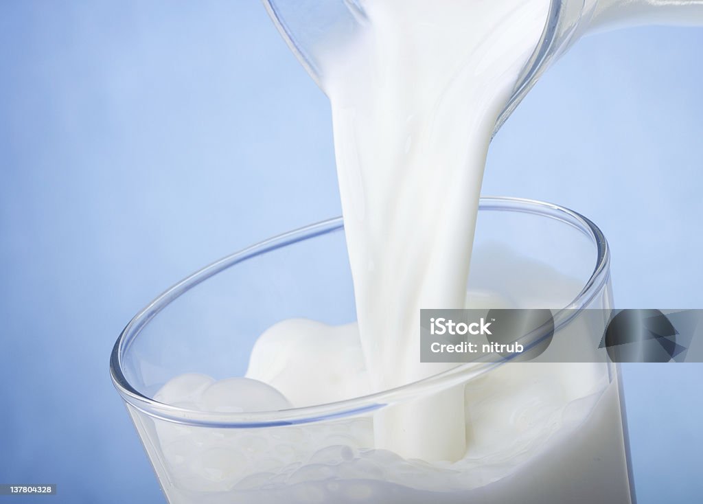 milk pouring into glass Blue Stock Photo