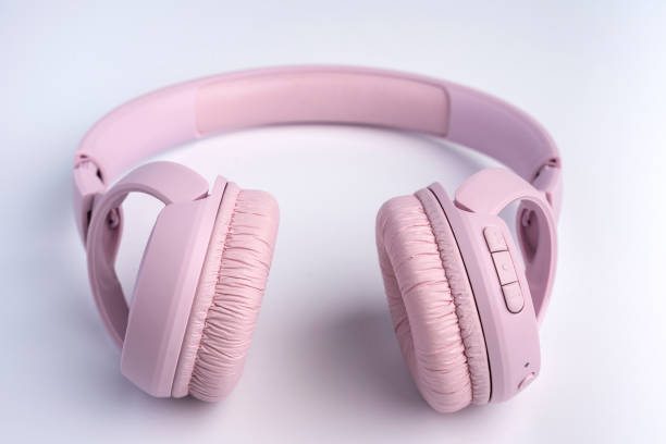 модные розовые беспроводные наушники на белом фоне. - pink and white radio стоковые фото и изображения