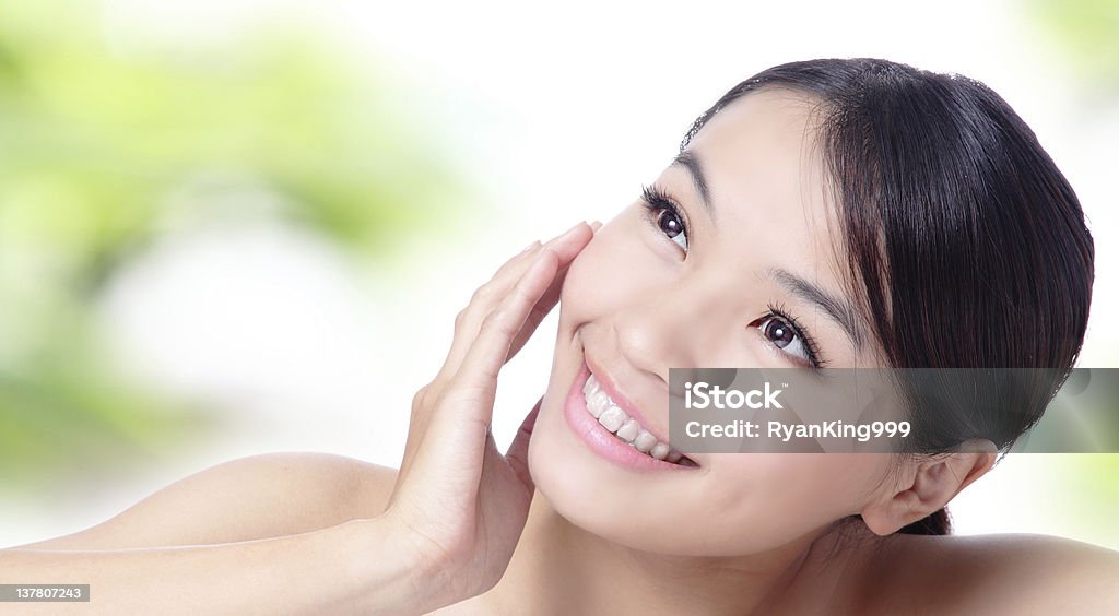 Close up of beautiful asian woman face Close up of beautiful asian woman face with green background Brown Stock Photo