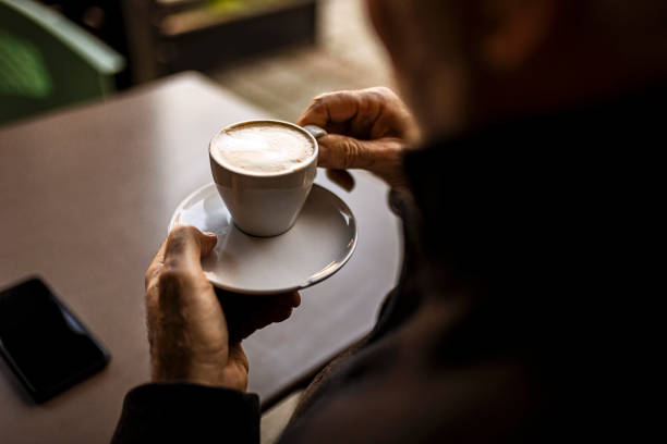 istock Unrecognizable senior man drinking coffee ,focus on coffee cup 1378082349