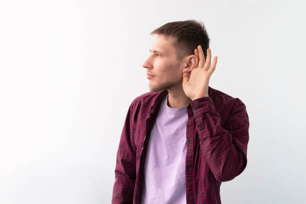 istock young male holding his hand over ear, hearing problems concept 1378083425