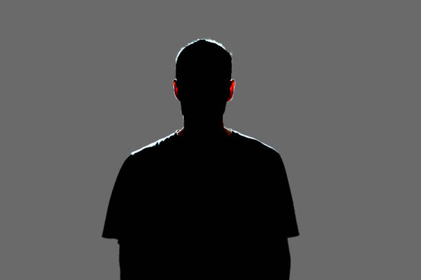 isolated dark male silhouette in the shadow, studio portrait stock photo