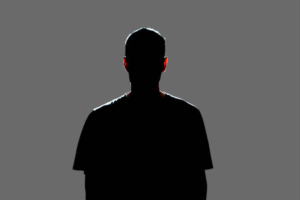 isolated dark male silhouette in the shadow, studio portrait - man silhouette imagens e fotografias de stock