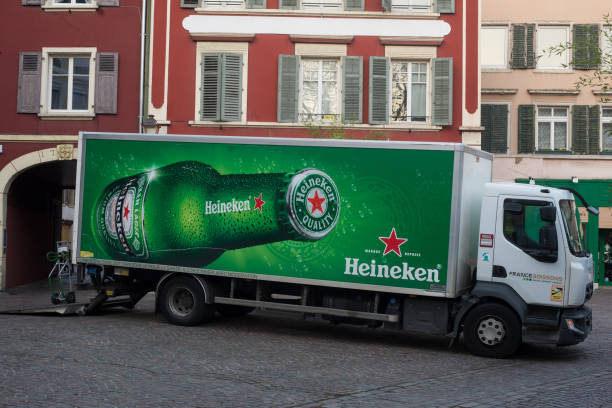 widok profilu ciężarówki dostawczej heineken zaparkowanej na ulicy w pobliżu restauracji - heineken international zdjęcia i obrazy z banku zdjęć