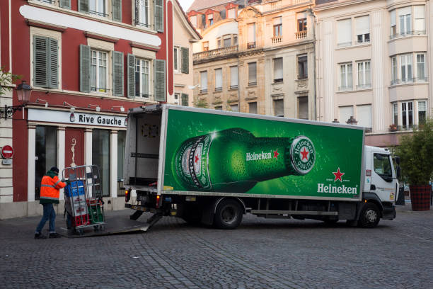 delivery man unloading Heineken  goods from drinking delivery truck parked in the street near restaurant stock photo