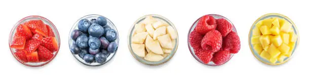 Photo of Set of Greek yogurt raspberry, mango, strawberry, blueberry, banana parfait in jars on a white isolated background