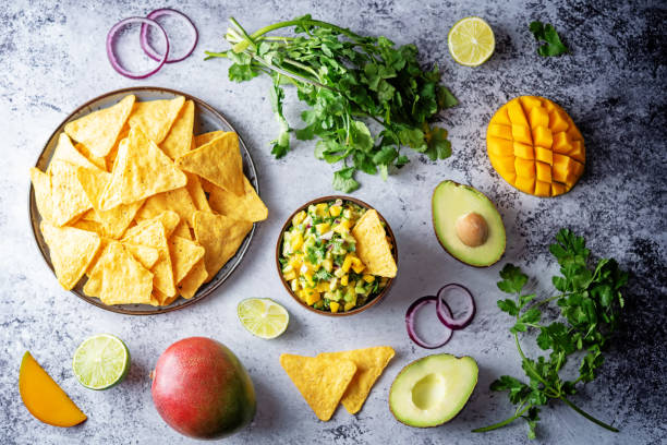 guacamole de mango con chips de maíz e ingredientes para prepararlo - mango salsa fotografías e imágenes de stock