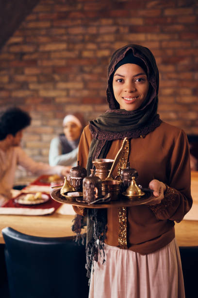 istock Traditional Middle Eastern woman serving Turkish coffee and looking at camera. 1378097779
