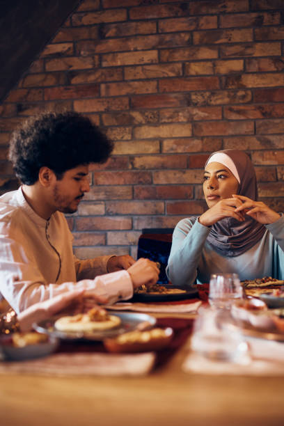 istock Young Muslim couple having lunch together at dining table. 1378099085