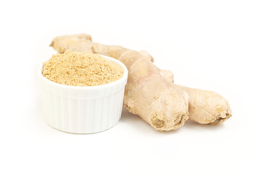 Ginger , root and ground ginger in white dish isolated on white background