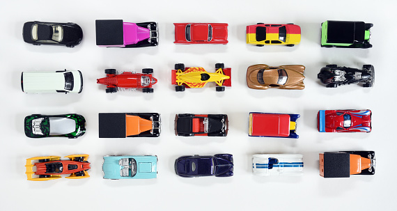 Four rows of die cast, miniature, toy sports cars and trucks isolated on white background.