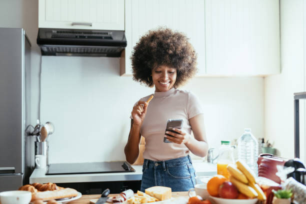 istock African American woman using phone and eating snack 1378114676