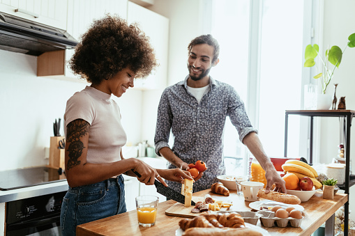 Multiracial heterosexual couple in kitchen, preparing French food
