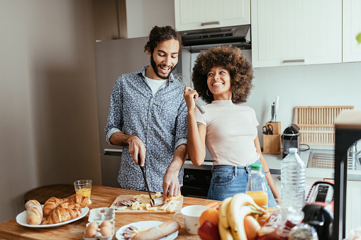 Multiracial heterosexual couple in kitchen, preparing French food