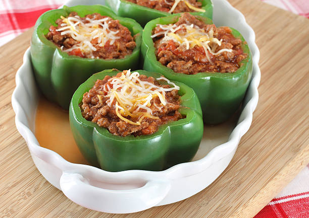 Stuffed Green Peppers Oval baking dish of stuffed green peppers with selective focus on foremost pepper. stuffed pepper stock pictures, royalty-free photos & images