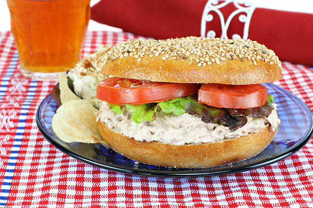 panino al tonno su un bagel ai semi di sesamo. - tuna tuna salad bagel sandwich foto e immagini stock