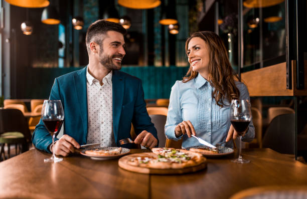 istock Beautiful couple eating pizza together in a restaurant. 1378142803