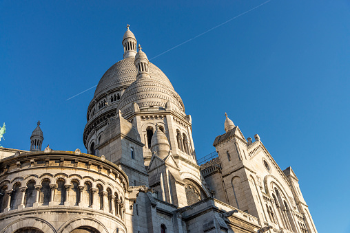 Partial view of the Basilica of the Sacred Heart of Paris (Basilica Sacred Coeur) at the top of Montmartre hill in Paris, France. It is the second place most visited by tourists in Paris.