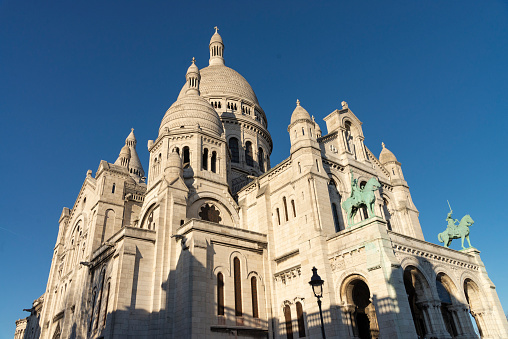 Side view of the Basilica of the Sacred Heart of Paris (Basilica Sacred Coeur) at the top of Montmartre hill in Paris, France. It is the second place most visited by tourists in Paris.