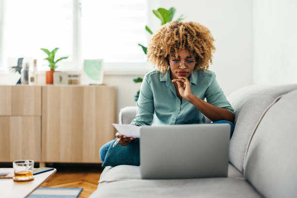 istock Portrait of a Beautiful Woman Looking at a Document While Working on her Laptop 1378158014