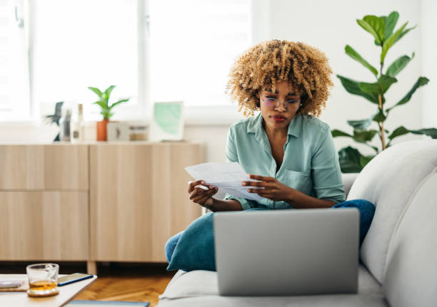 Portrait of a Beautiful Woman Looking at a Document While Working on her Laptop