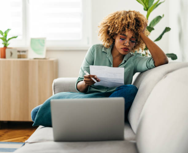 istock Portrait of a Beautiful Woman Looking at a Document While Working on her Laptop 1378158026