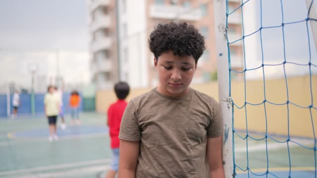 Sad boy at a sports court