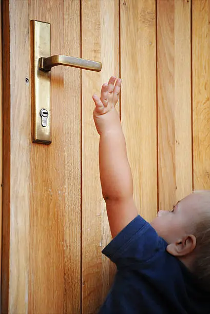 little boy try to reach doorhandle