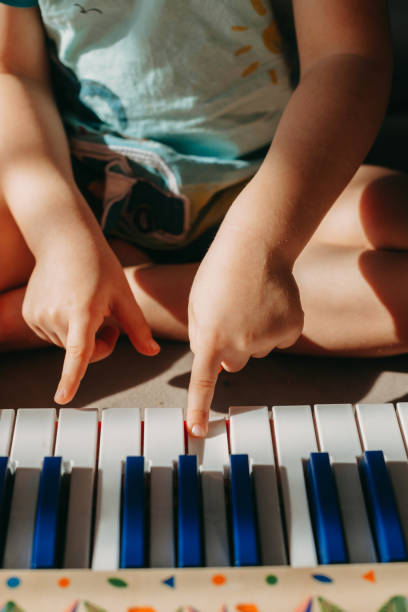 nahaufnahme der finger des babys auf einer klaviertastatur. home-konzept. kindesentwicklung. - music child pianist learning stock-fotos und bilder