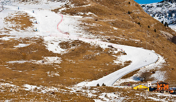 Global warming effect? A winter shot of an Italian ski resort with artificial snow due to high temperatures and lack of snowfall. artificial snow stock pictures, royalty-free photos & images