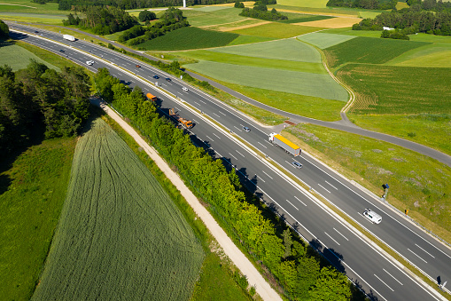 Aerial view of curvy highway with cars and trucks in spring/summer.
