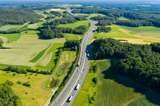 Aerial view of curvy highway with cars and trucks in spring/summer.