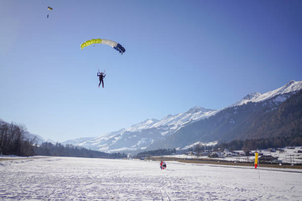 istock Female paraglider comes down to snowy landing 1378259210
