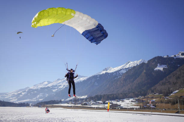 istock Female paraglider comes down to snowy landing 1378261036