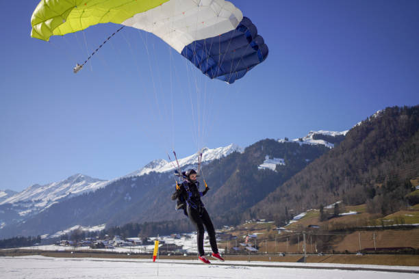 istock Female paraglider comes down to snowy landing 1378261057