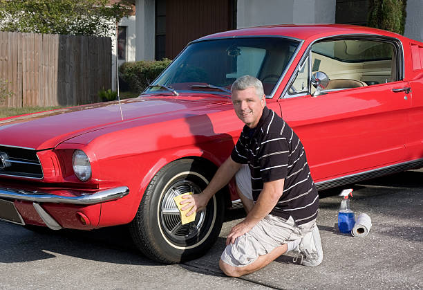 middle aged man cleaning his classic car