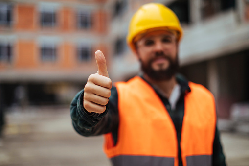 Young worker is happy and gives thumbs up