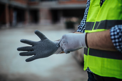 Photo of workers' hands while putting on protective gloves