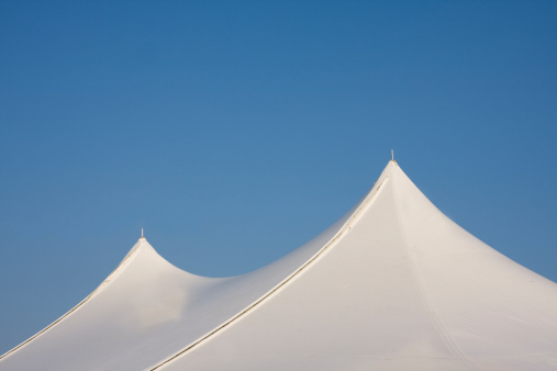 white tent top with solid blue sky. plenty of room for copy in sky.